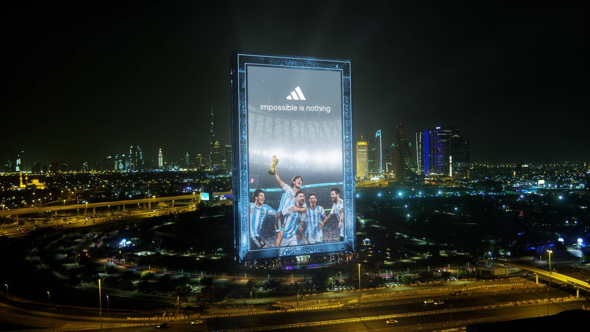 Billboard of Lionel Messi that reads "impossible is nothing" and shows him celebrating his World Cup win with past versions of himself