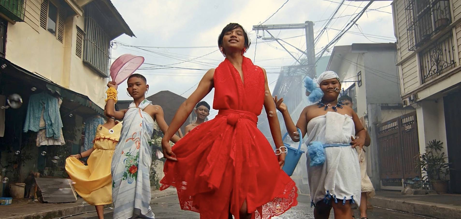 Screen Shot 2023-06-06 at 4.00.17 PM Children walking the streets in dresses designed from curtains